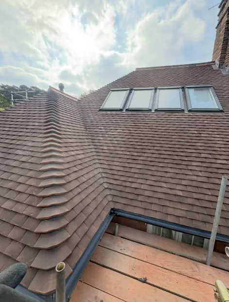 professional dry-fix ridge tile installation on a reddish-brown tiled roof in Farnham — Mitchell's Roofing