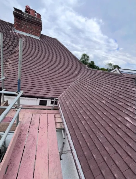 newly laid terracotta interlocking tiles on a brick house with scaffolding in Aldershot — Mitchell's Roofing