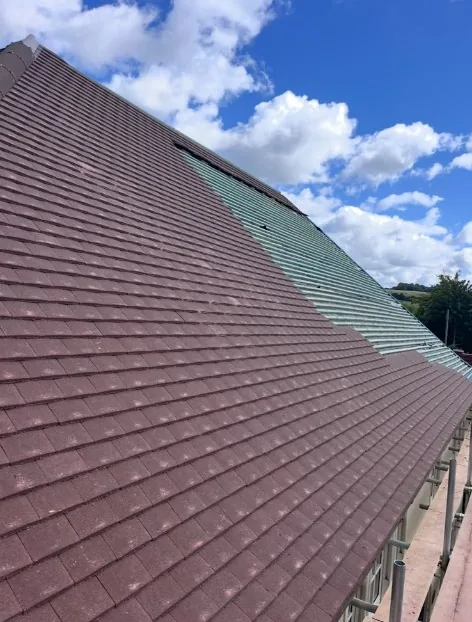 clay tile roof with four skylights and brick chimney after professional tiling in Liphook — Mitchell's Roofing